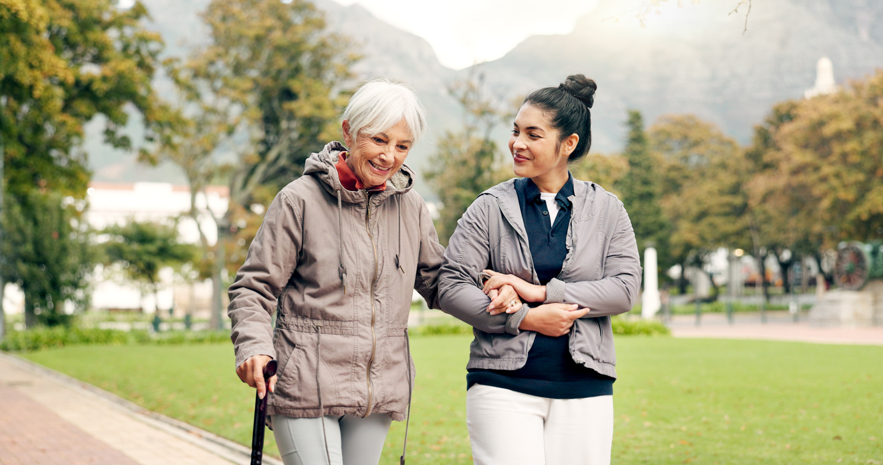 support worker assisting elderly woman in park australia